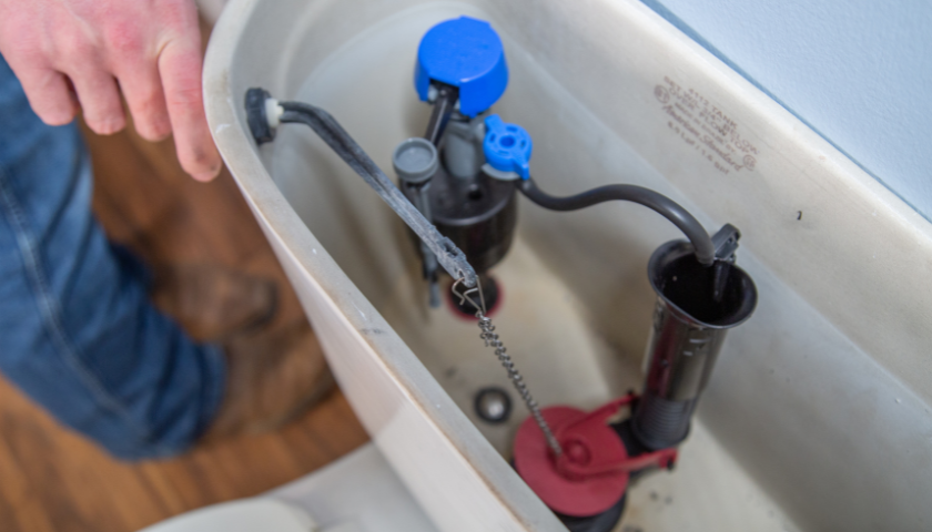 This image shows the inside of a toilet, specifically focusing on the chain and flapper.