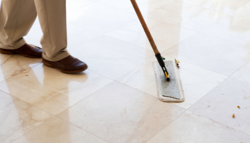 This image shows a push broom cleaning a tile floor.