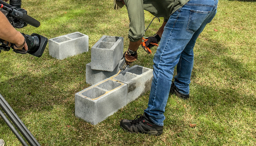 This image shows a person gluing concrete blocks together.