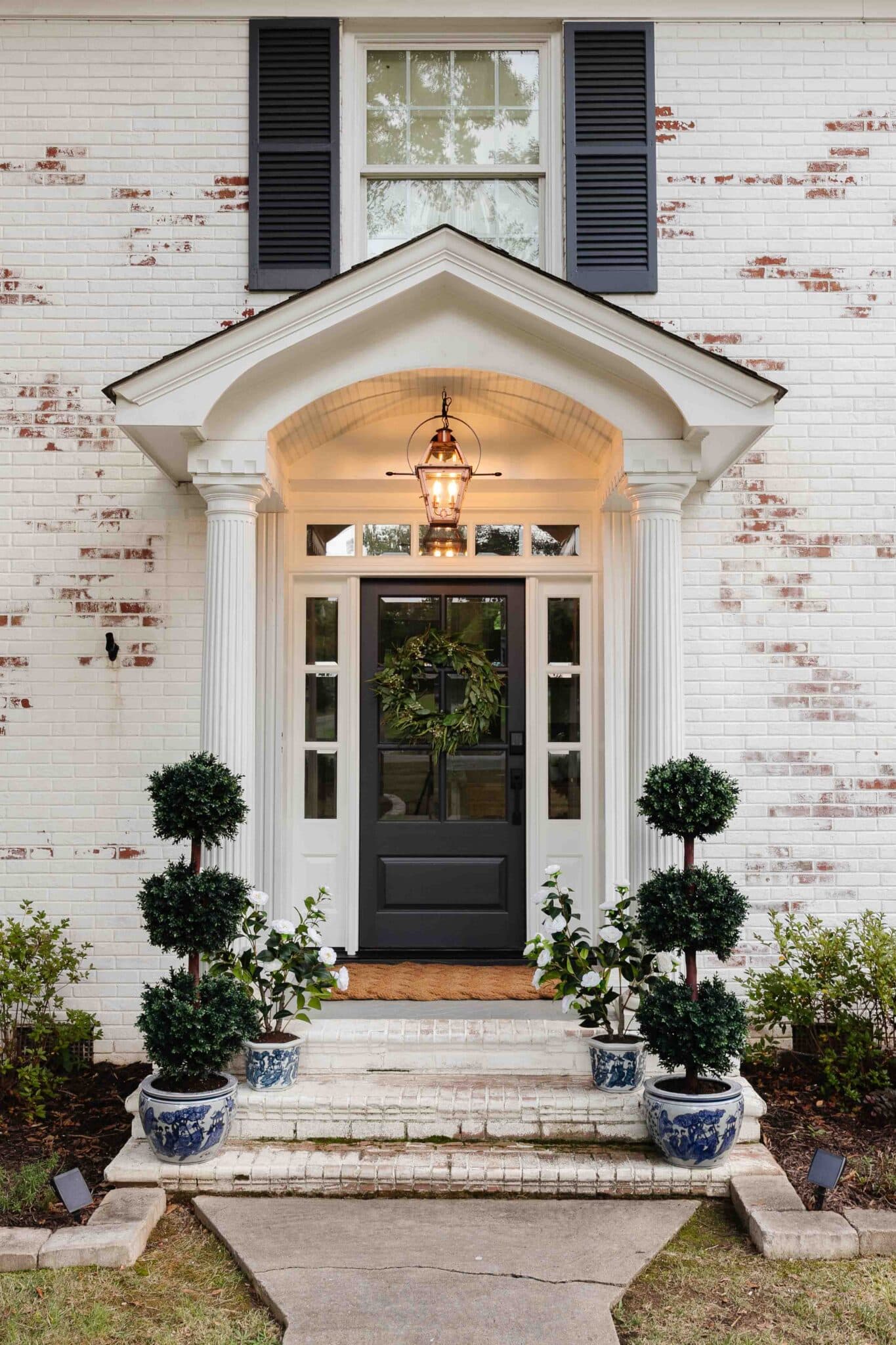 colonial front porch decor with gas lantern lookalike and blue and white planters