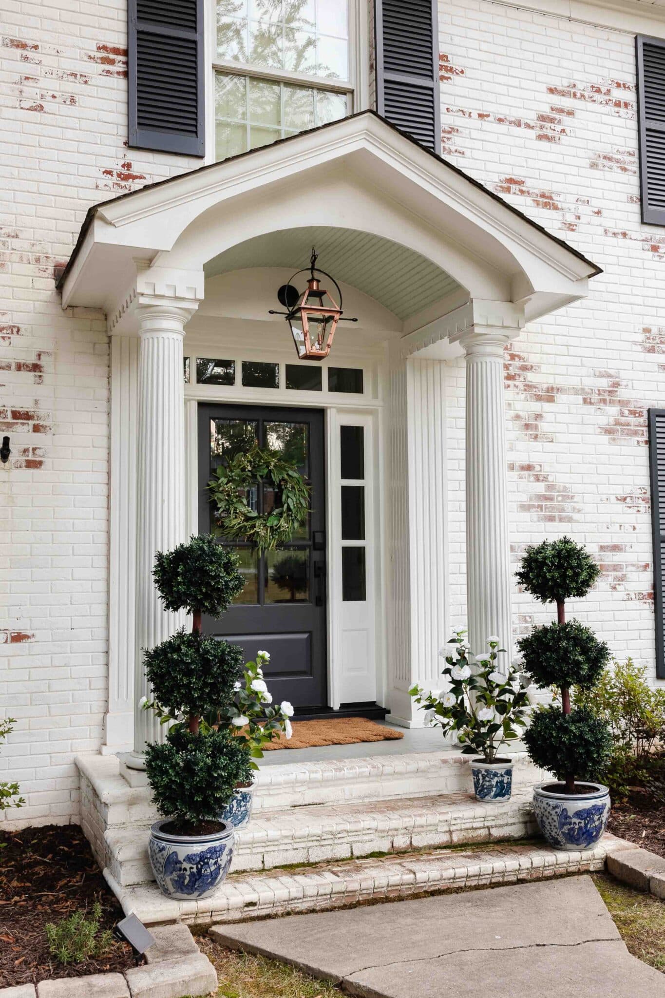 colonial front porch decor with gas lantern lookalike and blue and white planters