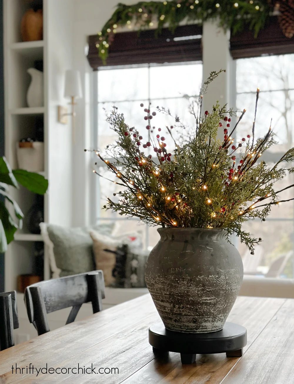 lighted branches and greenery in vase