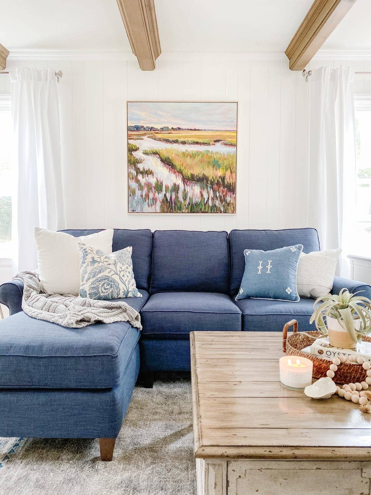 coastal living room with blue sofa and white walls