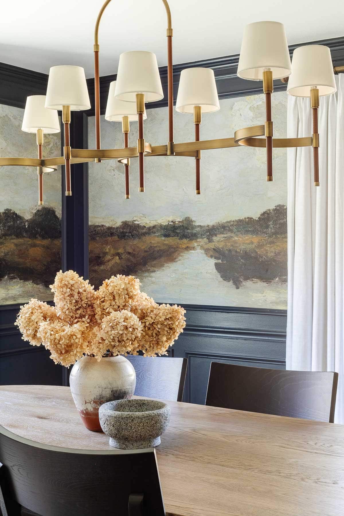 scenic landscape mural in dining room with shaded chandelier