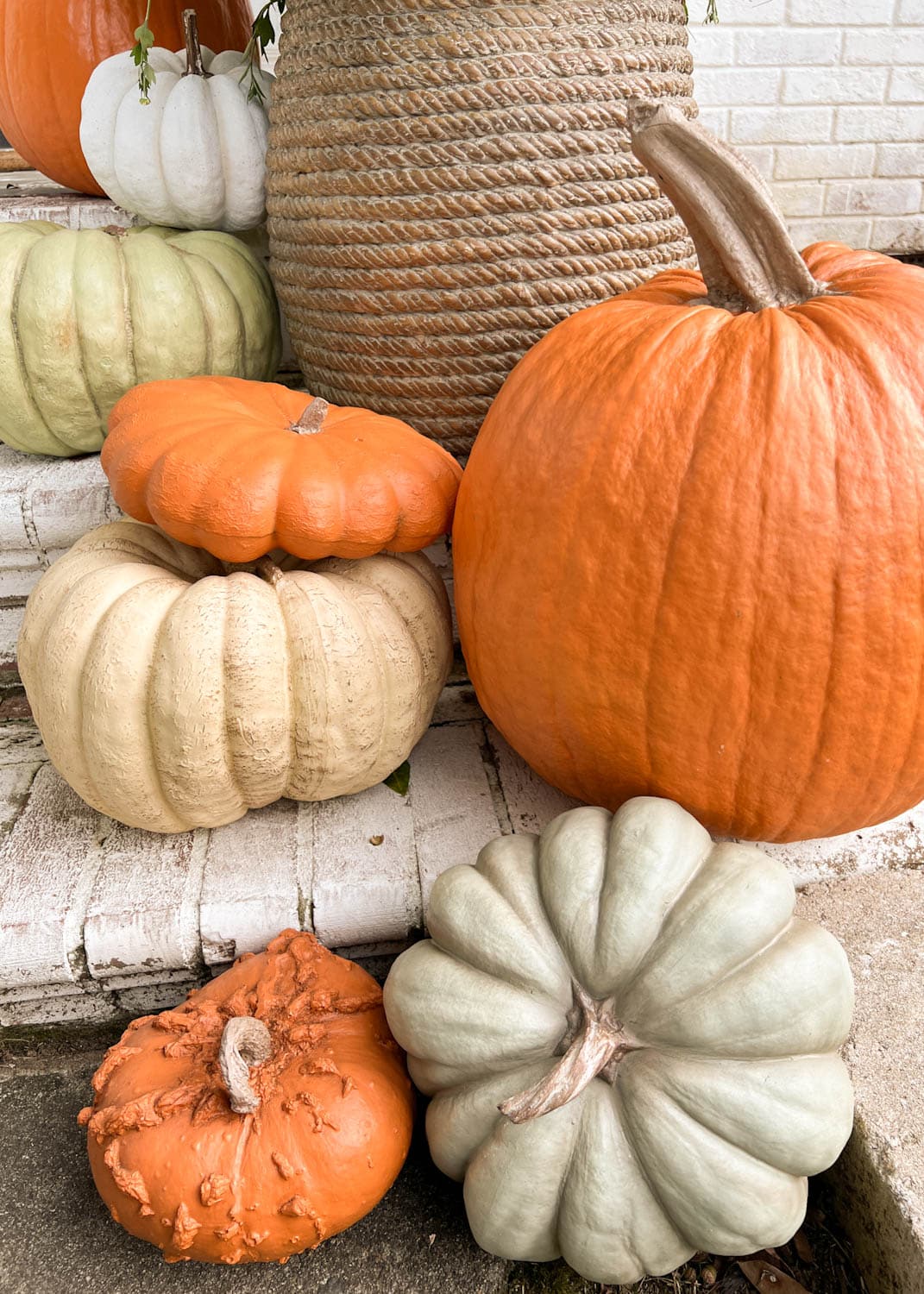 realistic fake pumpkins on limewashed brick porch steps