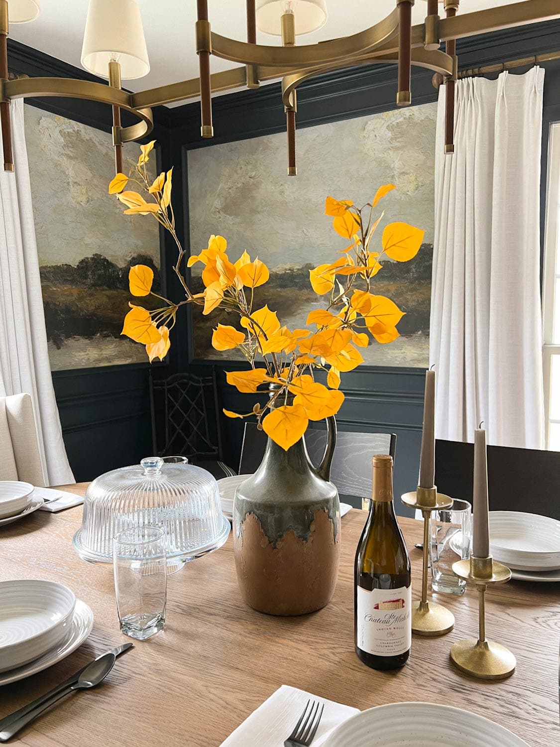 fall centerpiece vase of yellow aspen leaves on a dining table