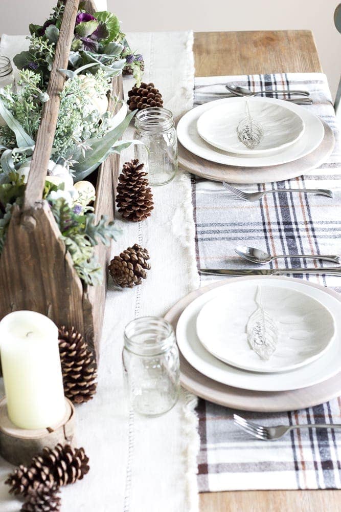 creative fall centerpiece using a wooden toolbox, ornamental cabbage, and gourds on a dining table