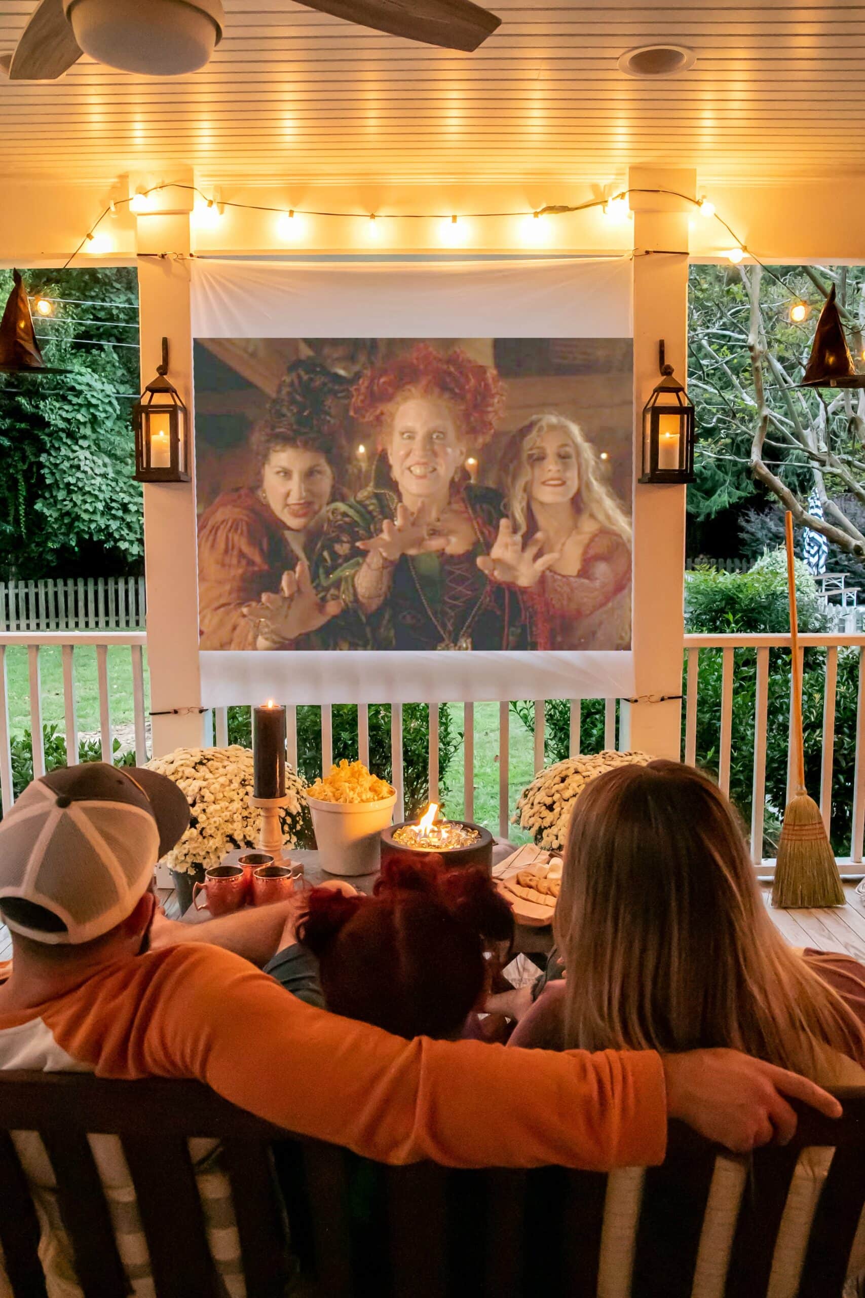 hocus pocus showing on an outdoor movie screen on a back porch decorated for a fall party