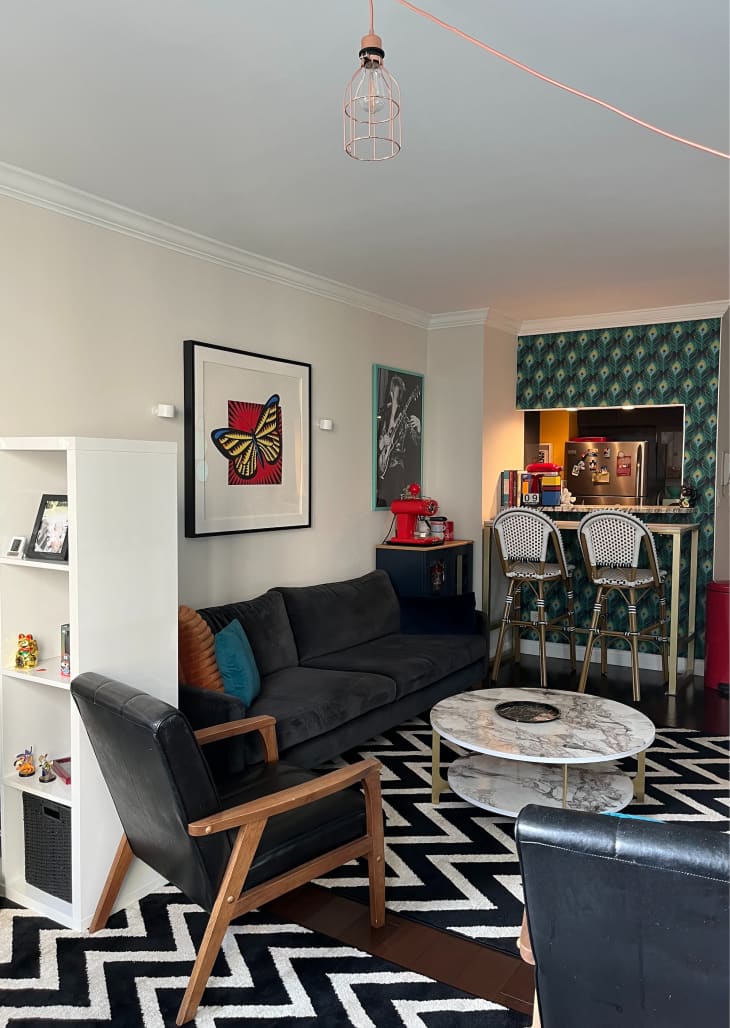 white living room with black velvet sofa and one wallpaper accent wall at bar area