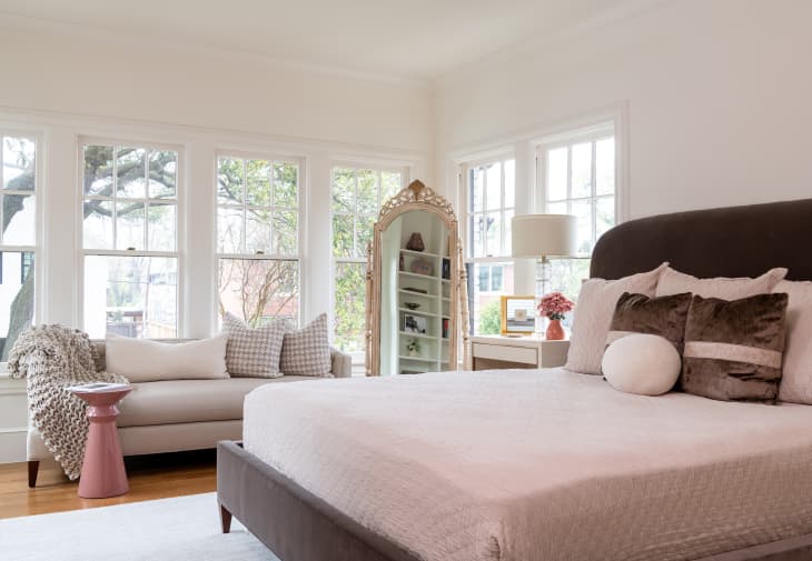 Decorative pillows on top of sofa in bedroom.