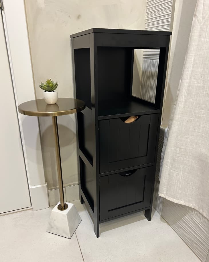 Black storage unit in newly remodeled bathroom.