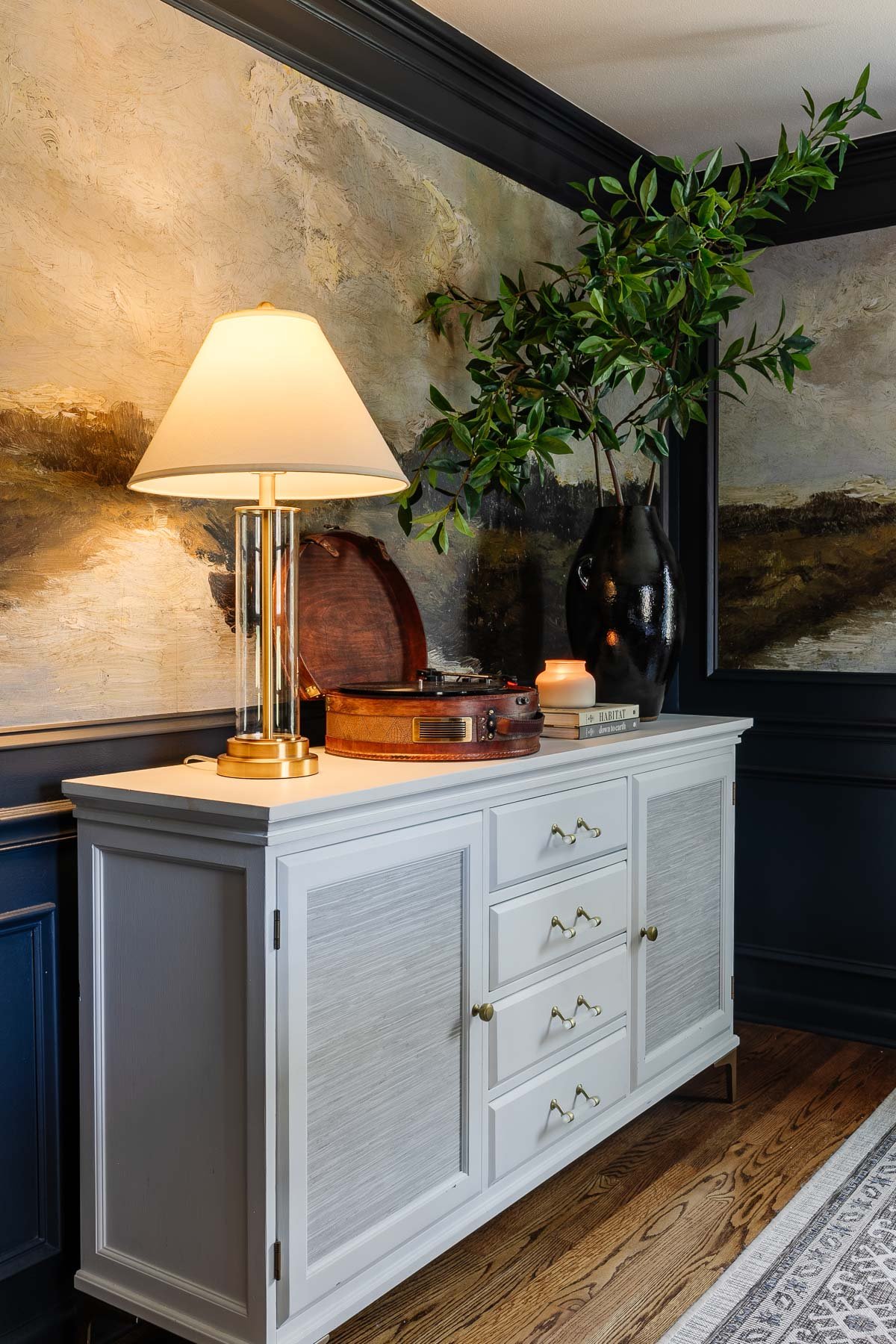 dining room buffet table decor with lamp, record player, and vase of branches