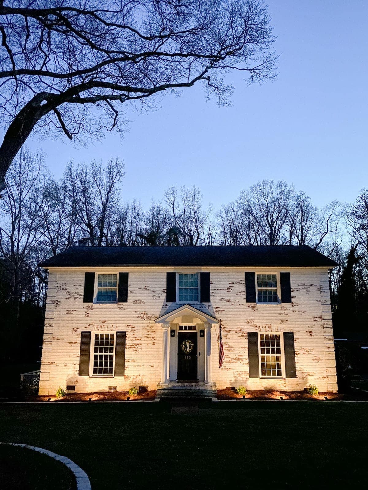 wireless landscape spotlights on a limewashed brick house