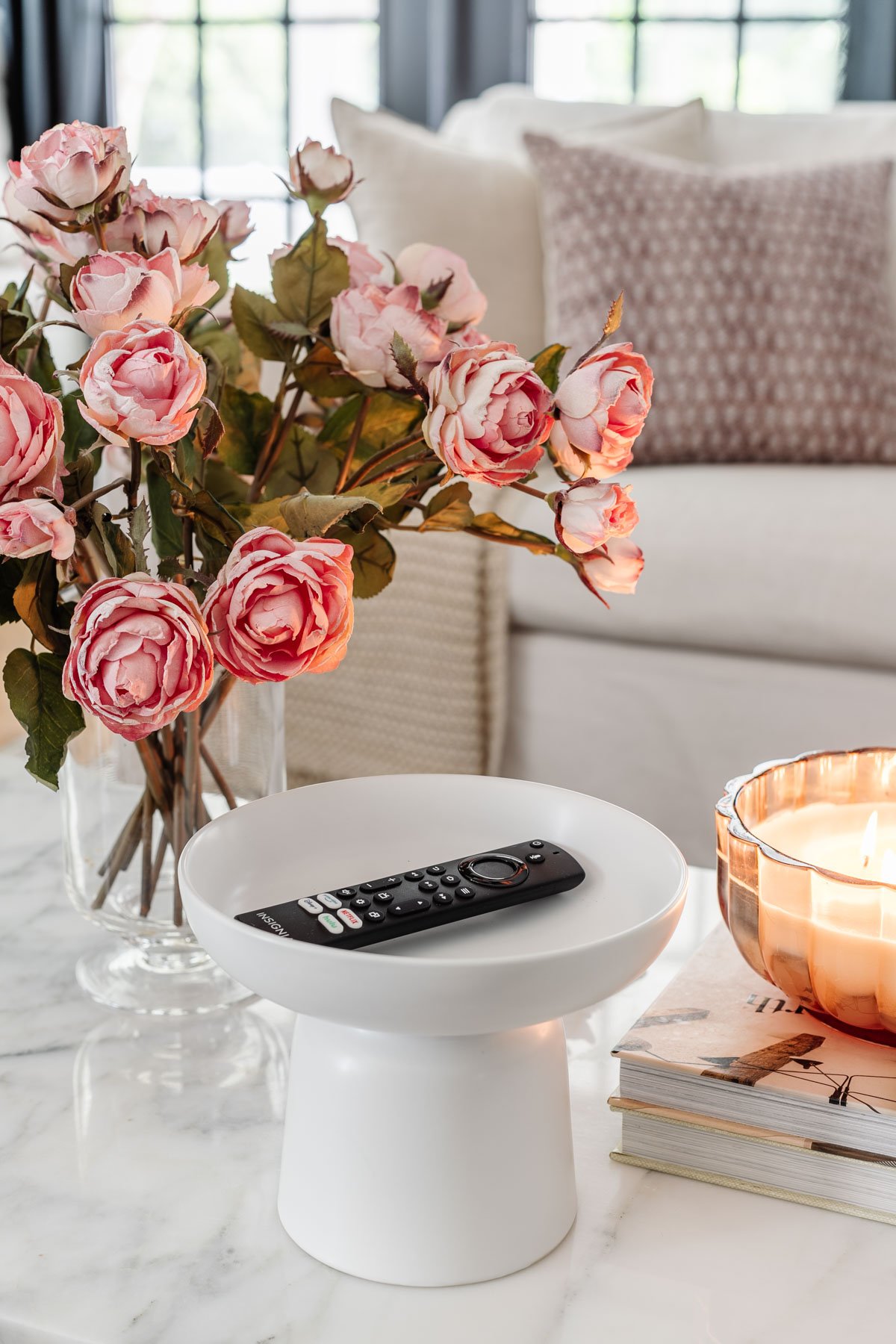 pedestal bowl used as a remote control holder on a coffee table