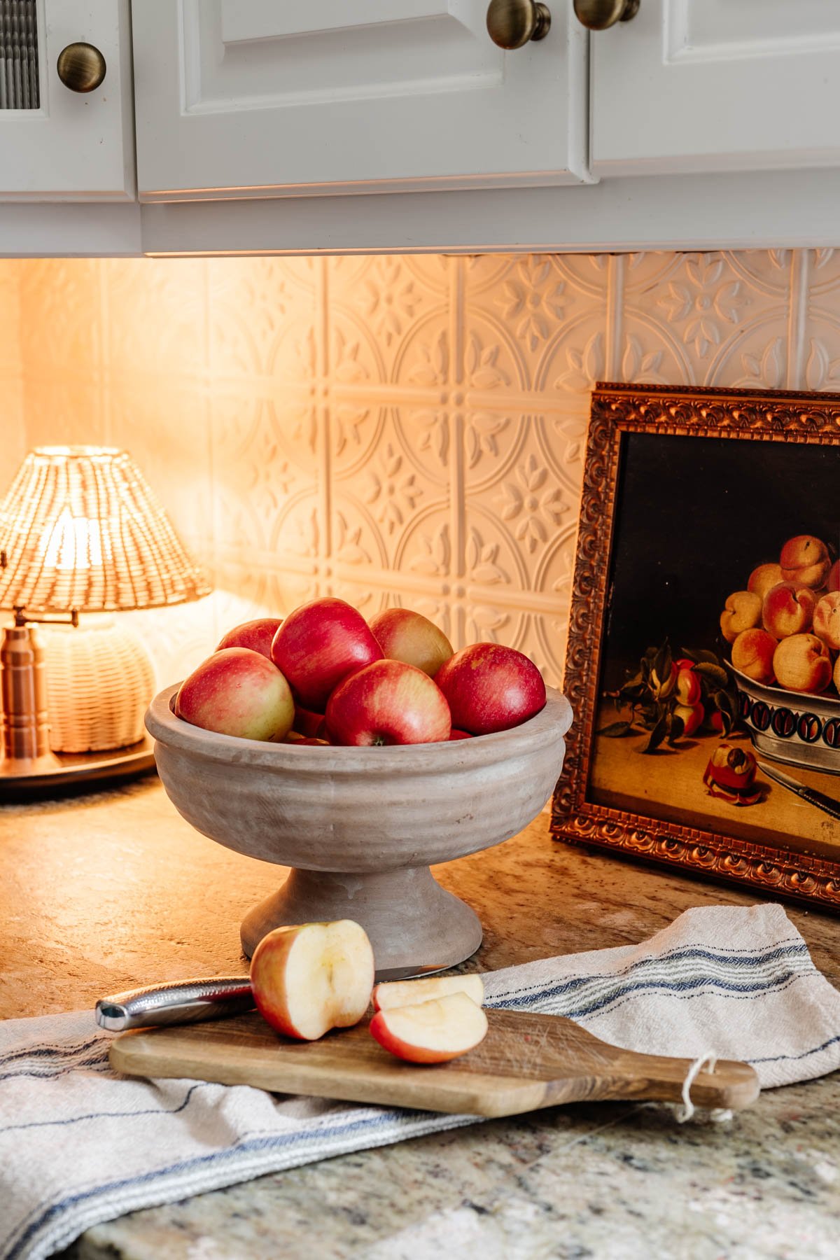 footed bowl used as a fruit bowl on a kitchen countertop