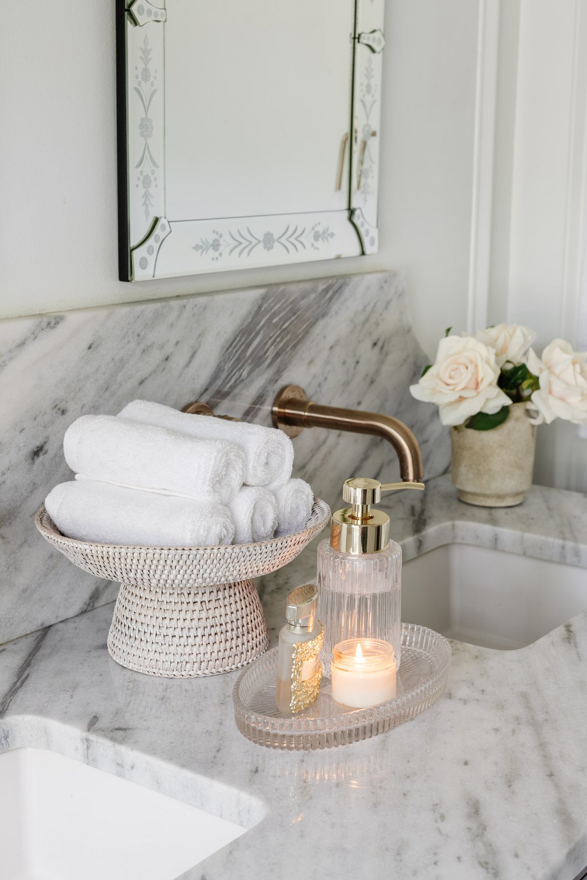 rattan pedestal bowl used as a towel holder on a bathroom countertop