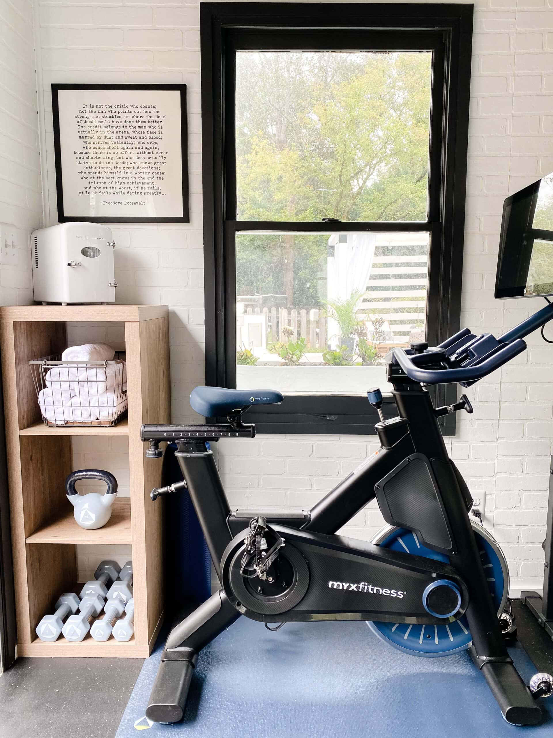 cardio bike in a gym shed with mini fridge and towels