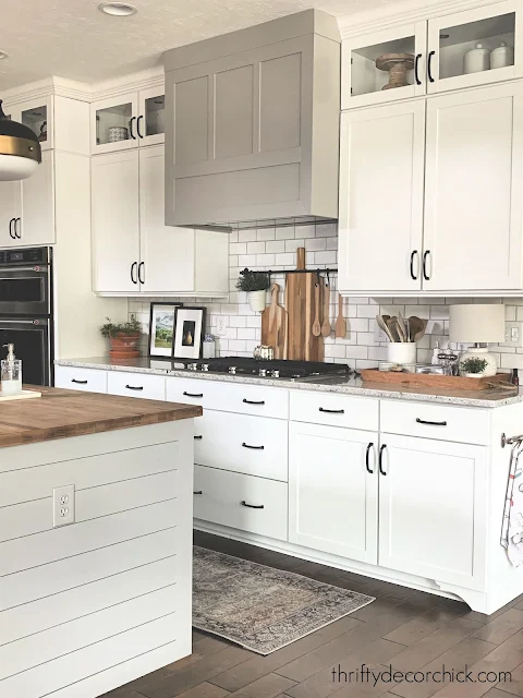 White kitchen gray island black brass accents