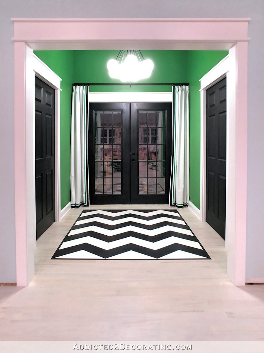 back entry of studio with painted chevron floor design and black painted doors