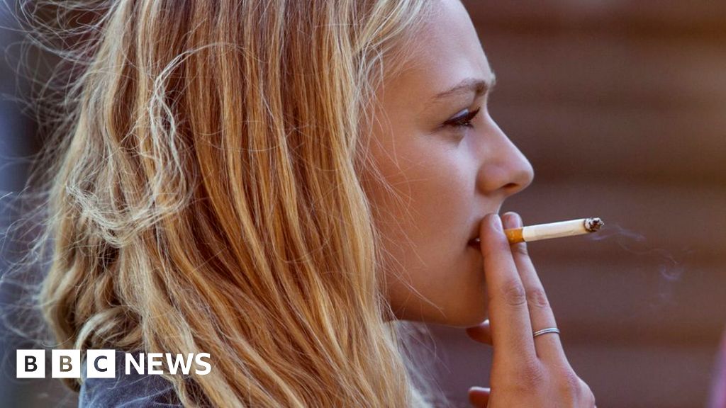 Blonde woman smoking cigarette - stock photo